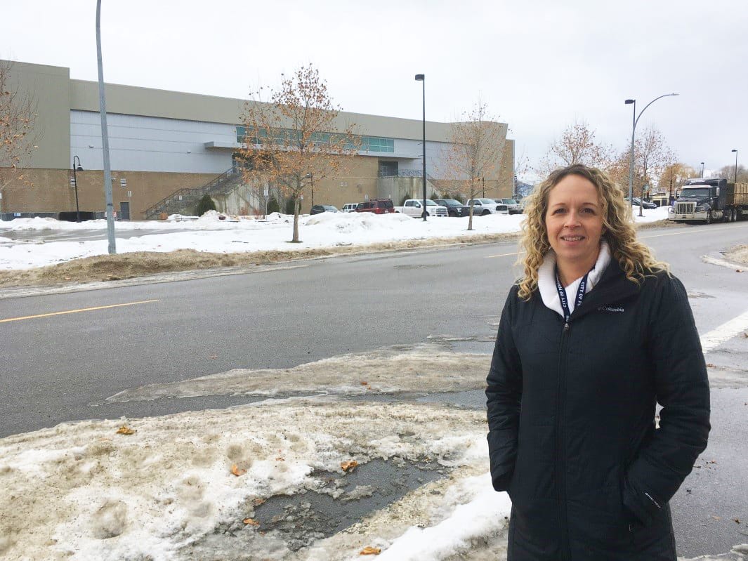 Woman standing in front of road and building
