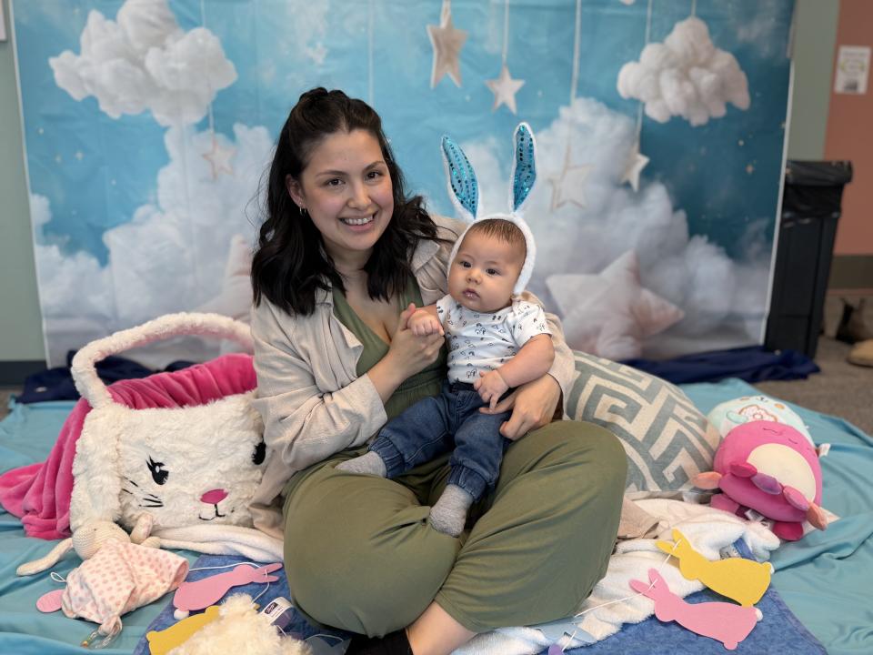 A mother and her baby pose in front of an Easter display at Baby Talk in Penticton.