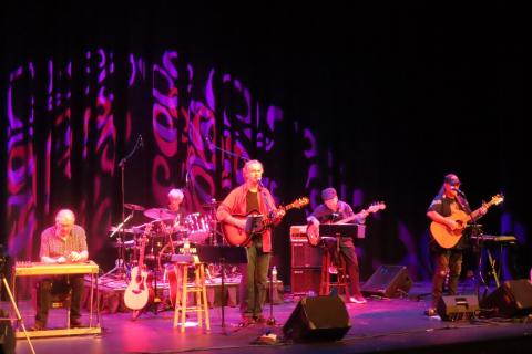 man on stage with a band